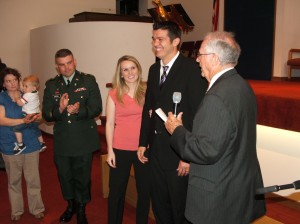 Chaplains Commission Director Dr. Robert Crick, right, commissions Chaplain Isfay, second from right.