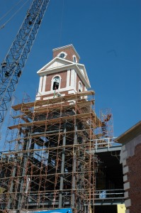 Workers remove scaffolding from the central commons tower of the new science and math complex.