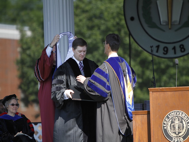 williams-receives-doctorate Rev. Mark Williams (center) is awarded the honorary doctorate degree from Lee University President Dr. Paul Conn (right). Preparing to place the hood is Lee board chairman Darrell Rice.