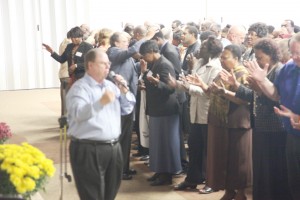 Care administrator Donnie Smith prays over conference delegates.