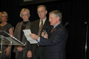 General Overseer Raymond Culpepper reads a resolution honoring Hollifield, center, while his wife, Mary, and daughter, Darlene, look on. 