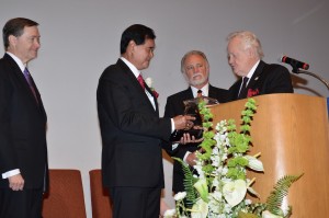 Pastor Niko accepts a plaque from PTS President Dr. Lamar Vest as General Overseer Mark Williams, left, and PTS Board Chairman Martin Taylor look on (click photo to enlarge).