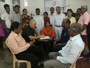 Bishop Ronnie Hepperly signs the agreement with the Sri Lankan delegation. 